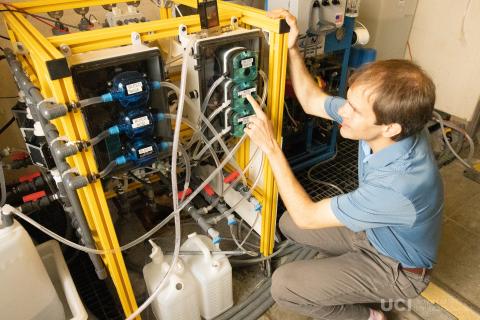 Professor Shane Ardo of the UC Irvine Department of Chemistry inspects carbon capture machinery owned by a company called Captura. 