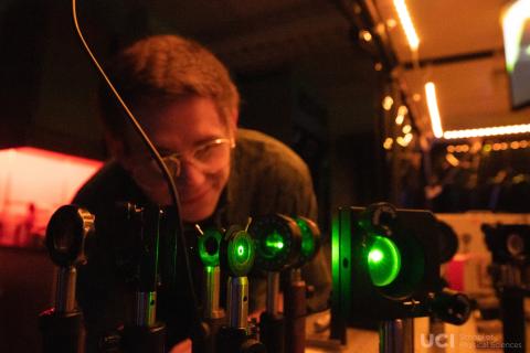 A photo of a graduate student at UC Irvine, Dave Knez, inspecting instruments in the Laser Spectroscopy Labs at the university.